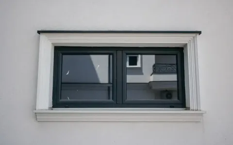 Tamni prozor na svetloj fasadi